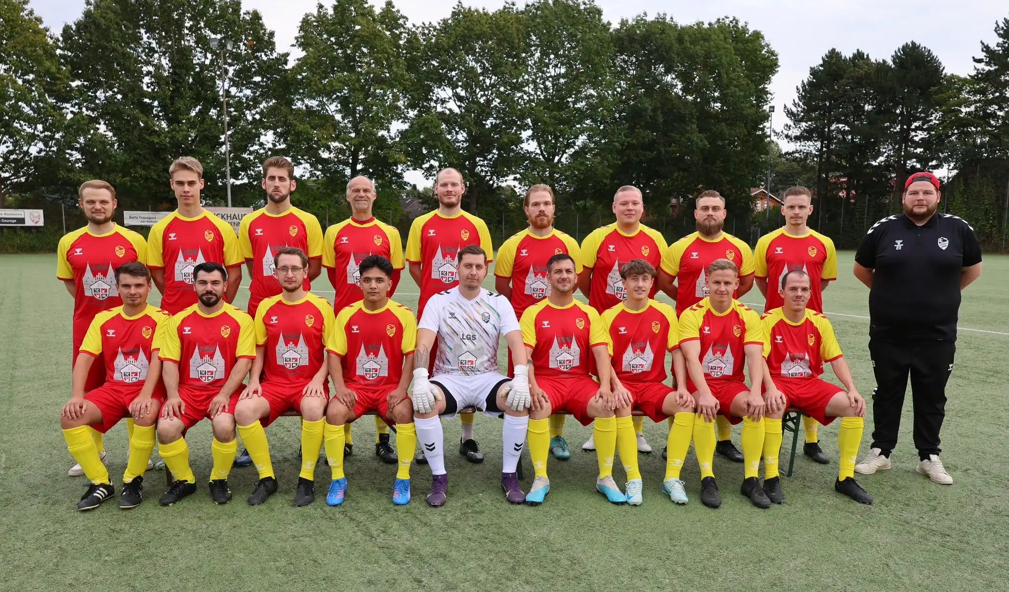3. Herren in roten/gelben Trikots, Torwart weiß, Trainer rechts auf Rasen